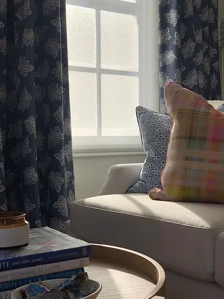 A living room with a chair, a table, and a window.