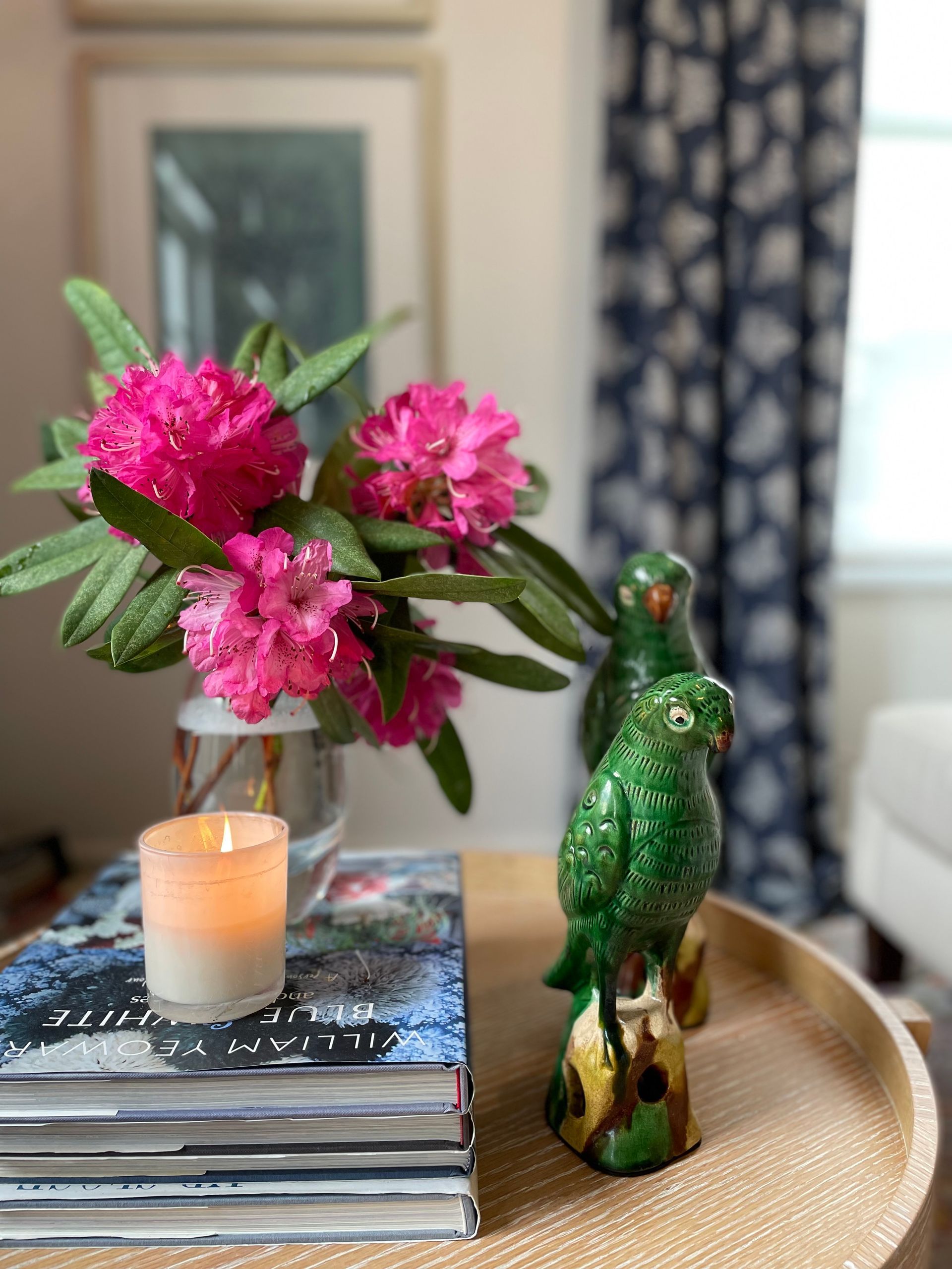 A table with vases , candles , a mirror and a plant on it.