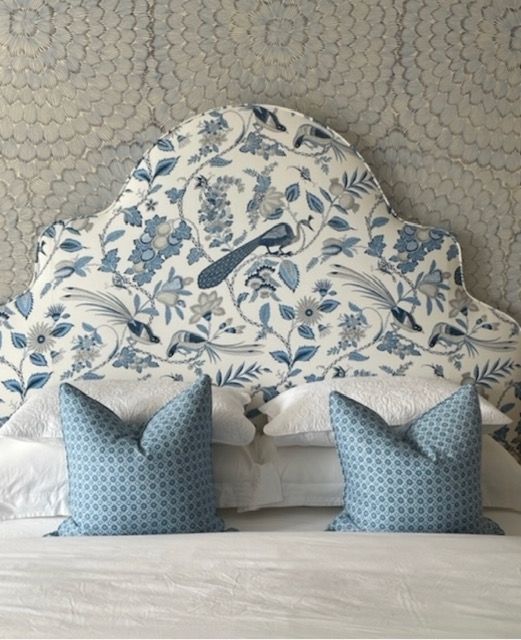 A bed with a blue and white headboard and pillows