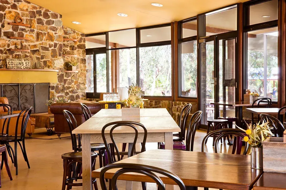 A restaurant with tables and chairs and a fireplace.