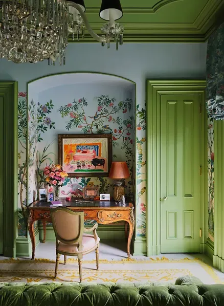 A room with green walls and a desk and chair