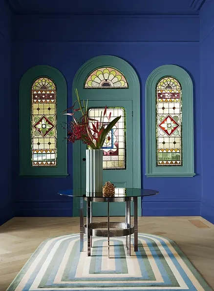 A room with blue walls and stained glass windows