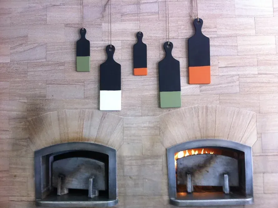 A fireplace with a bunch of cutting boards hanging from it