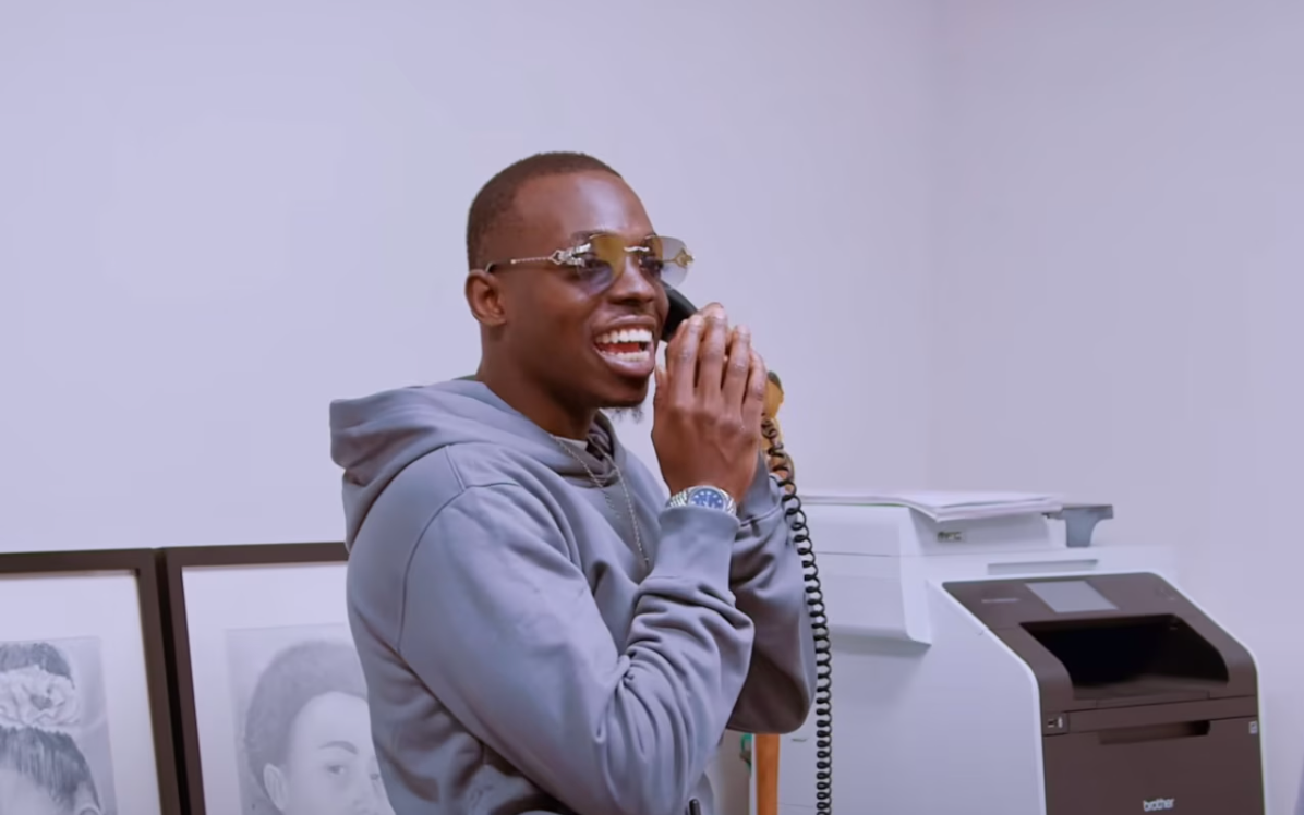 A man wearing sunglasses is talking on a telephone.