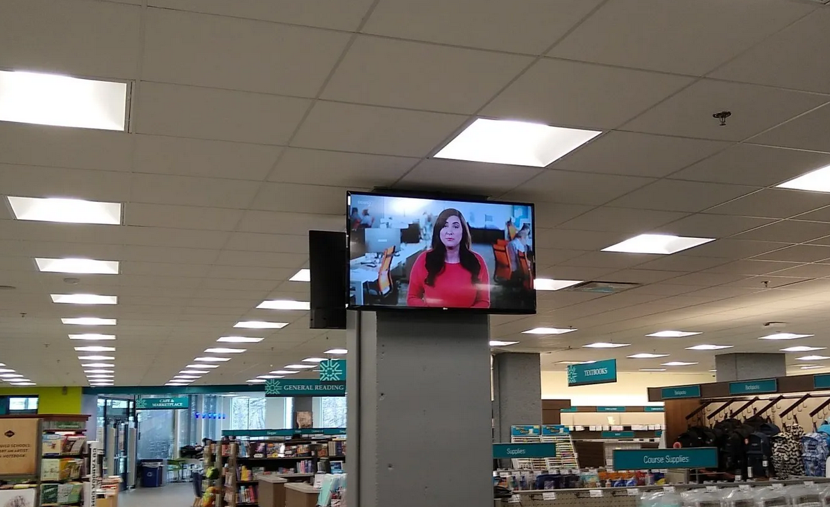 Two TVs custom mounted on a pillar inside a store by fisher custom av