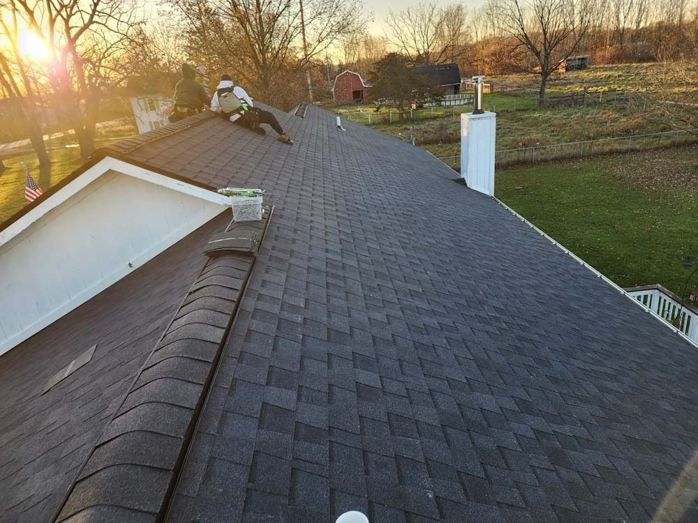 A man is working on the roof of a house.