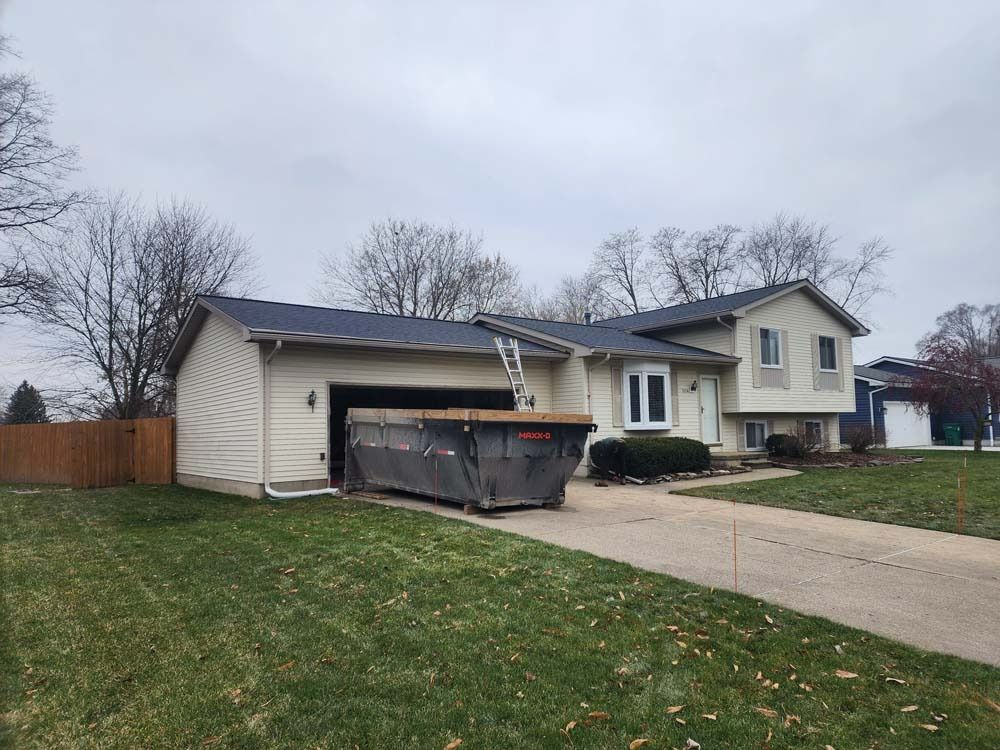 A large house with a dumpster in front of it.