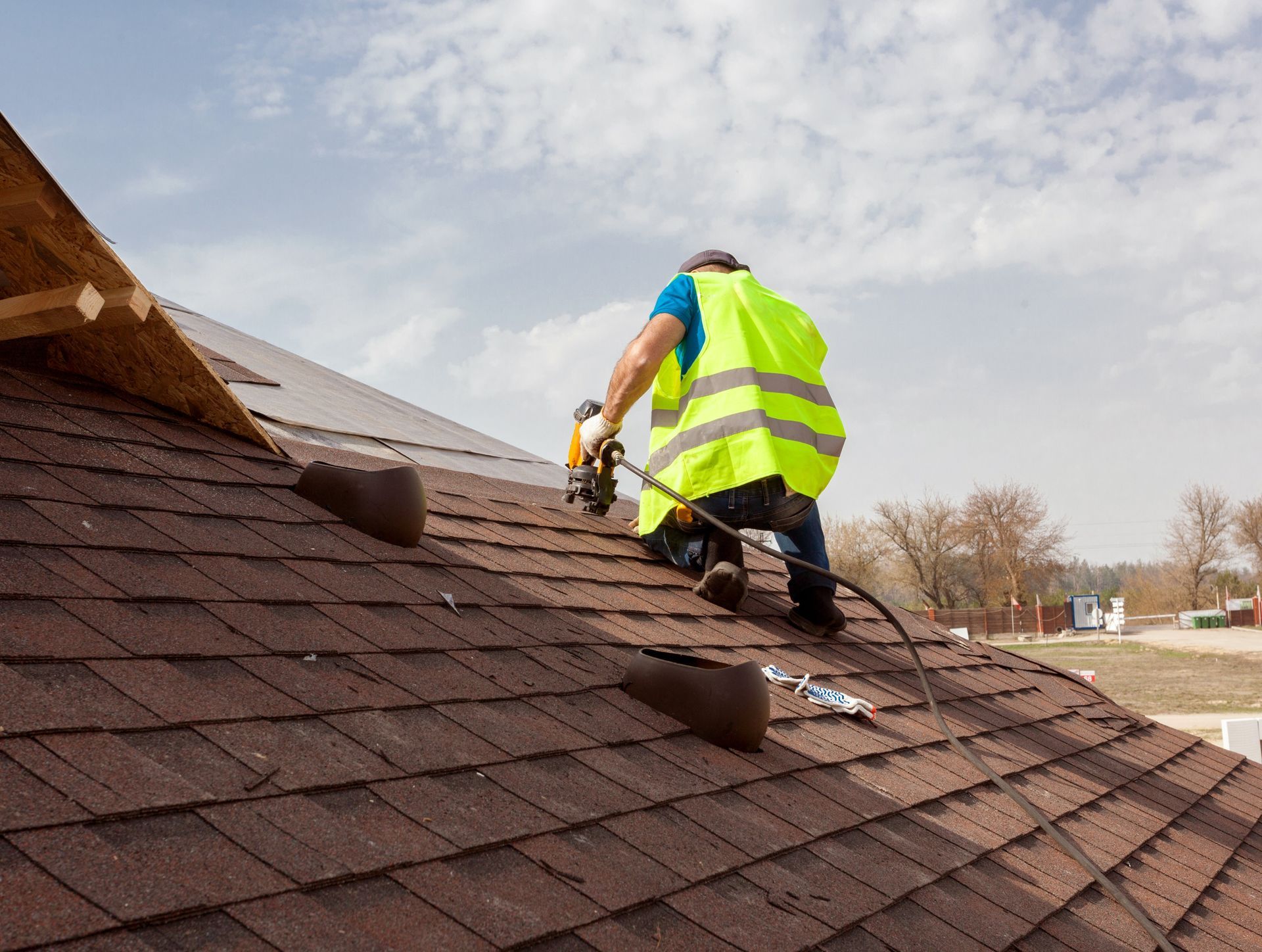 Expert commercial roofer installing ridge vents and box vents on a new shingle roof installation. Expert commercial roofer installing ridge vents and box vents on a new shingle roof installation.