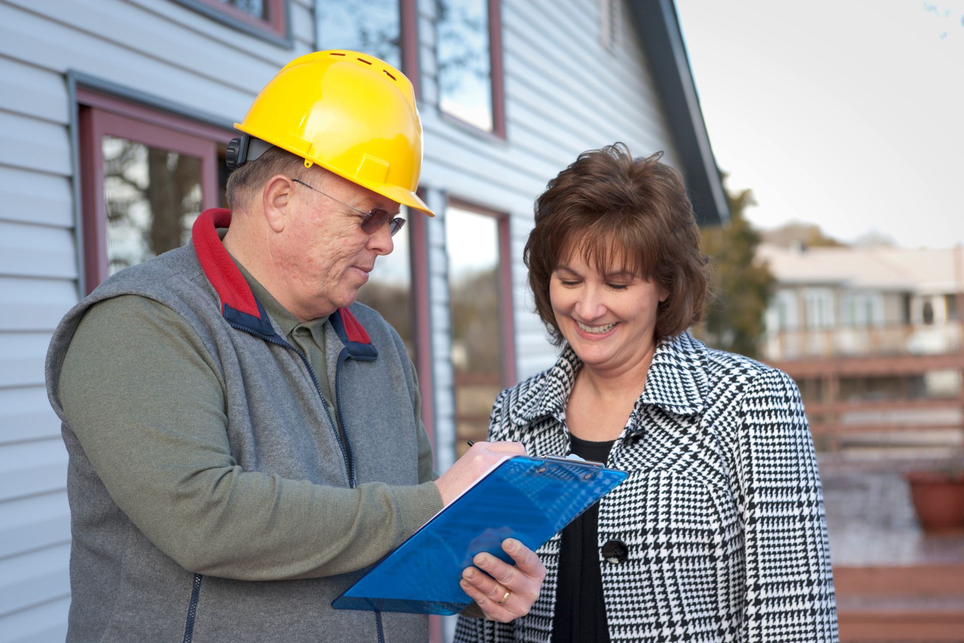 Roof contractor and a client go over roof construction plans.