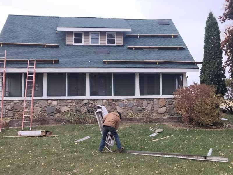 A man is working on the roof of a house
