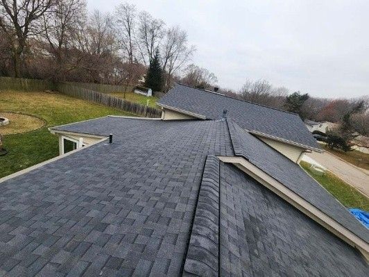 Close-up view of a roof with dark gray asphalt shingles. Close-up view of a roof with dark gray asphalt shingles.