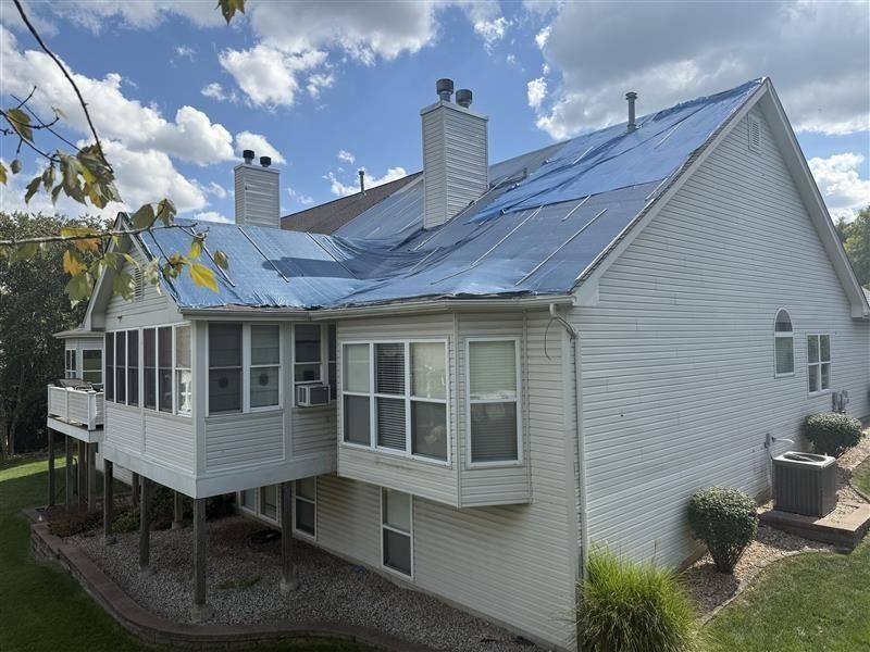 Light-colored house with a standing seam metal roof installed across multiple roof sections.