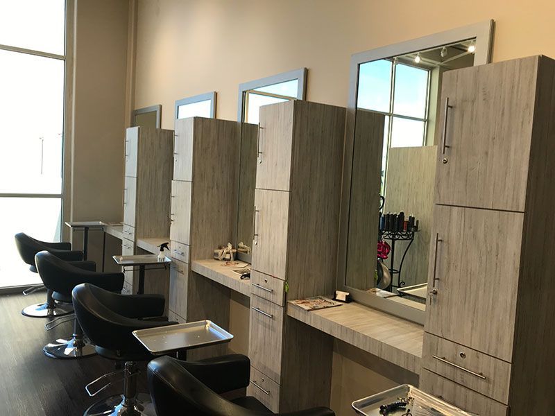 A row of chairs and mirrors in a hair salon.
