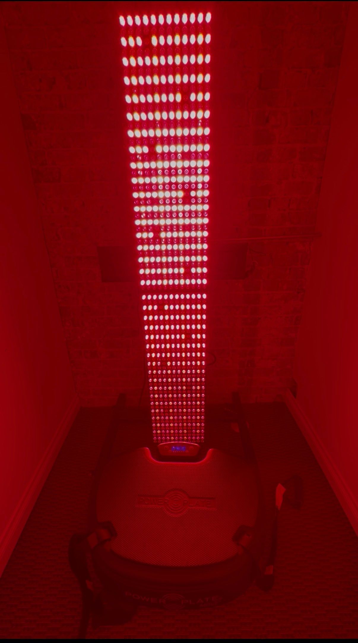 A man is standing in front of a red light.