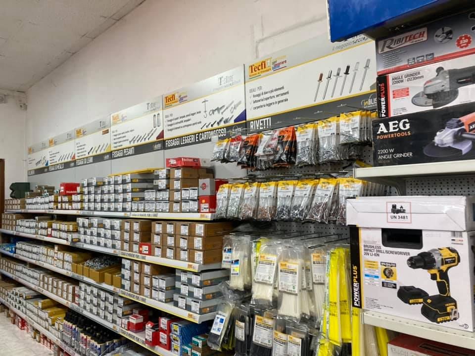 Scaffali di ferramenta pieni di elementi di fissaggio e utensili elettrici.