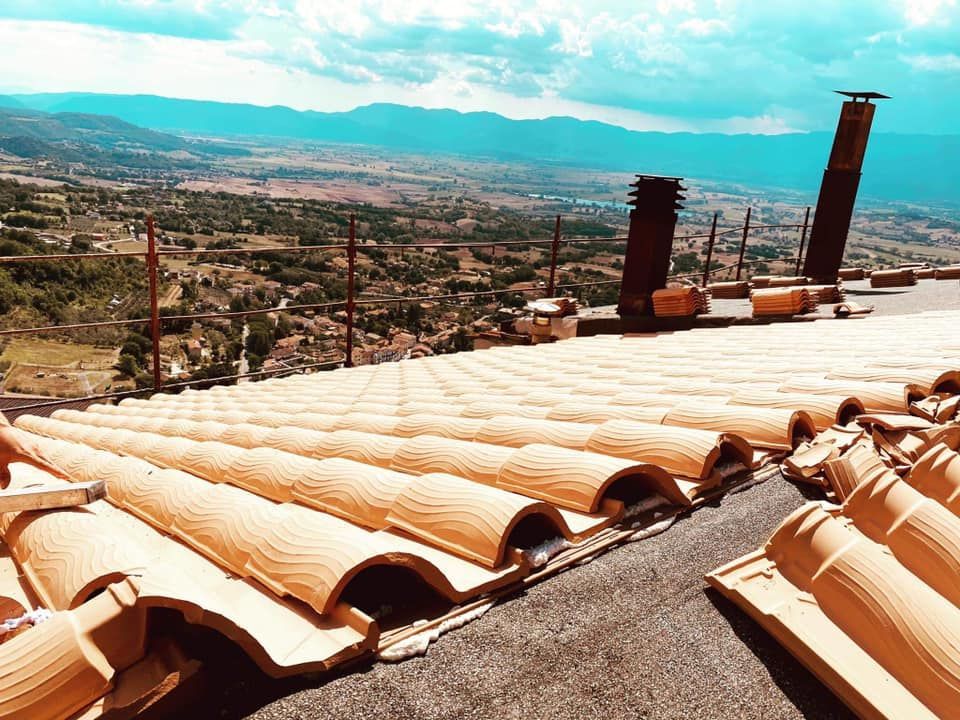 Tegole in terracotta con vista panoramica sotto un cielo nuvoloso.