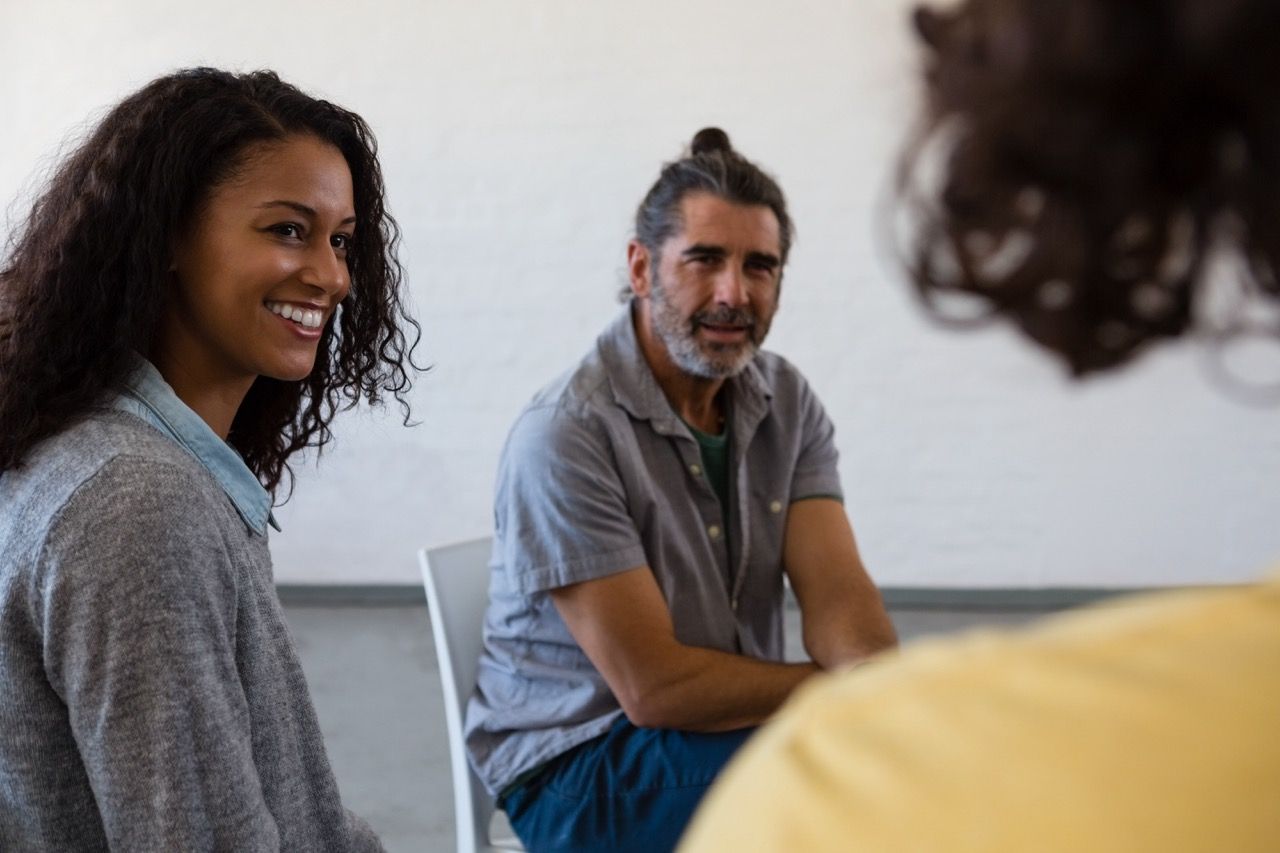 A group of people are sitting in a circle talking to each other.
