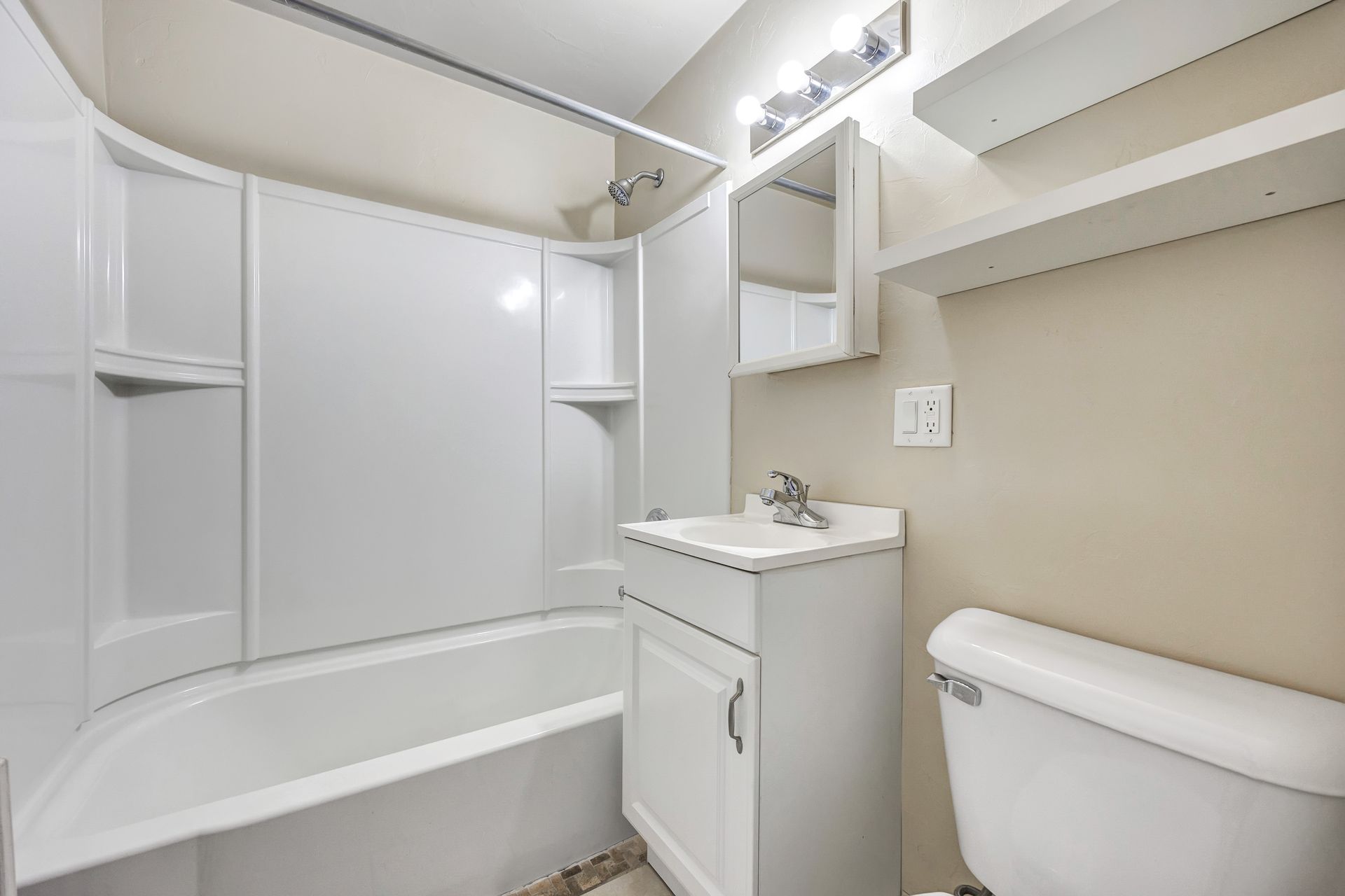 A bathroom with a sink , toilet , bathtub and mirror.