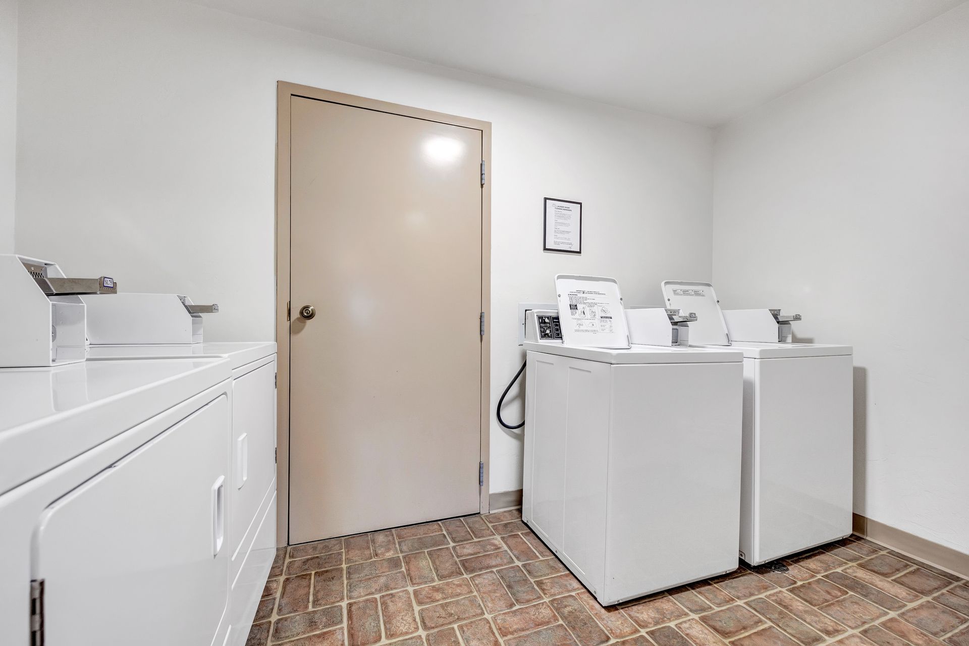 A laundry room with two washers and two dryers.