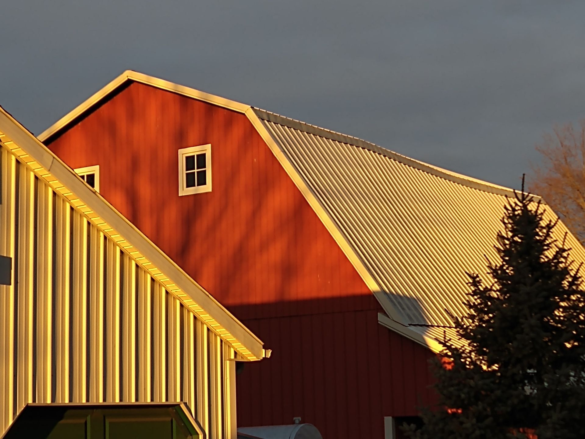 Evening sun on end of tall red barn