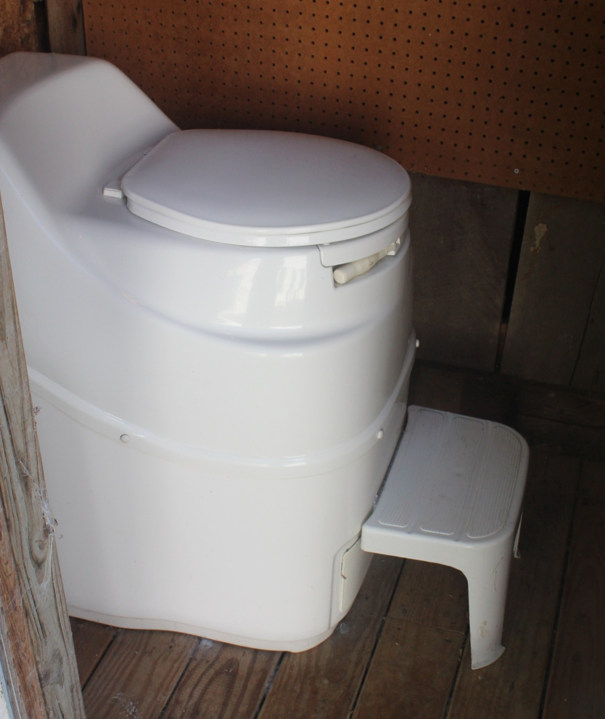 Photo of a compost toilet in a small room which was formerly the farm's outhouse