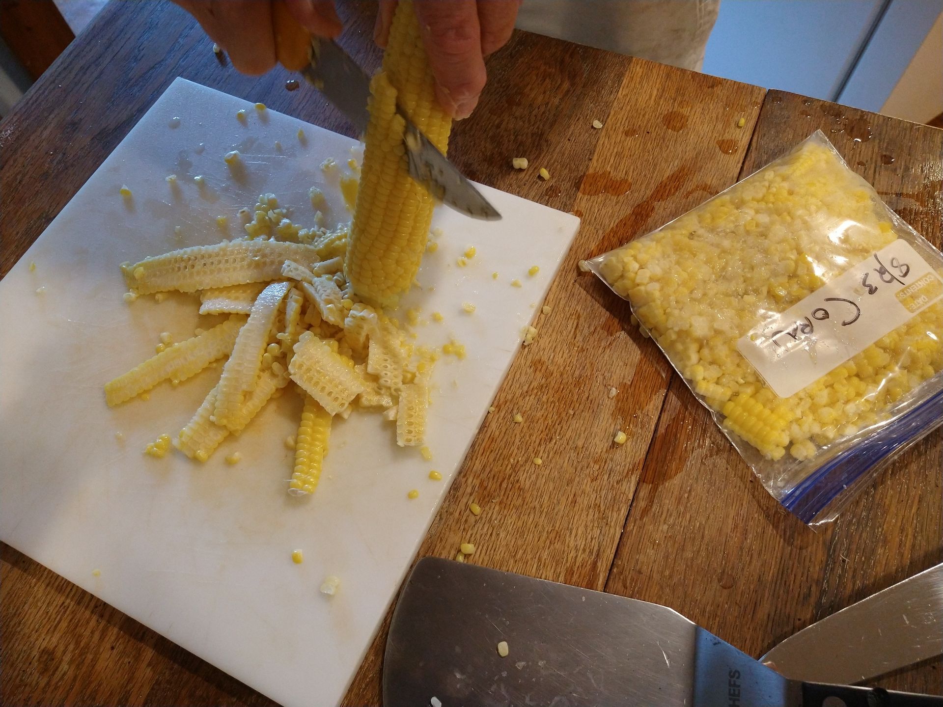 A sharp knife removes the blanched kernels of corn before placing them in freezer bags