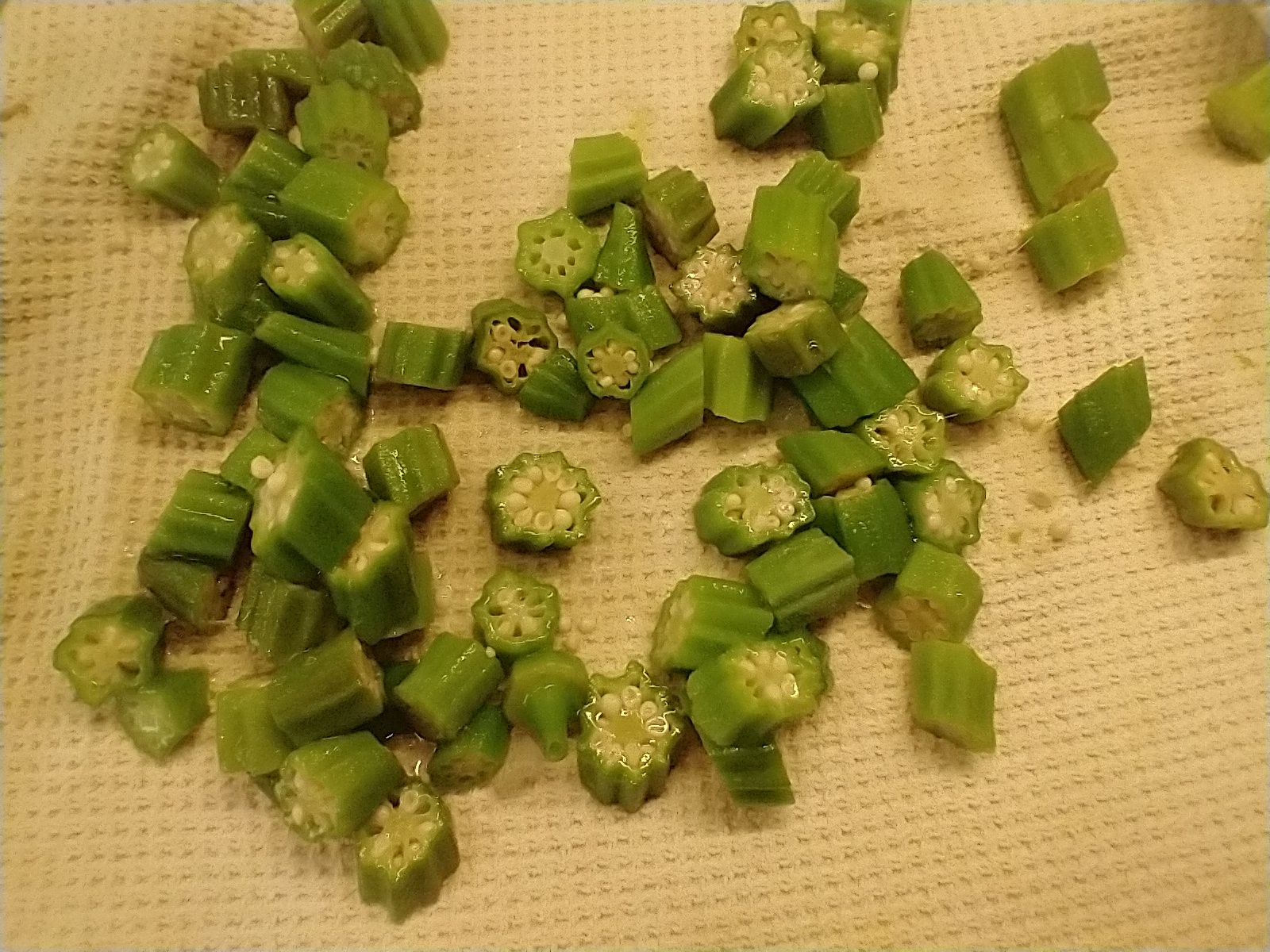Cut, steamed and cooled pieces of okra drying on a towel