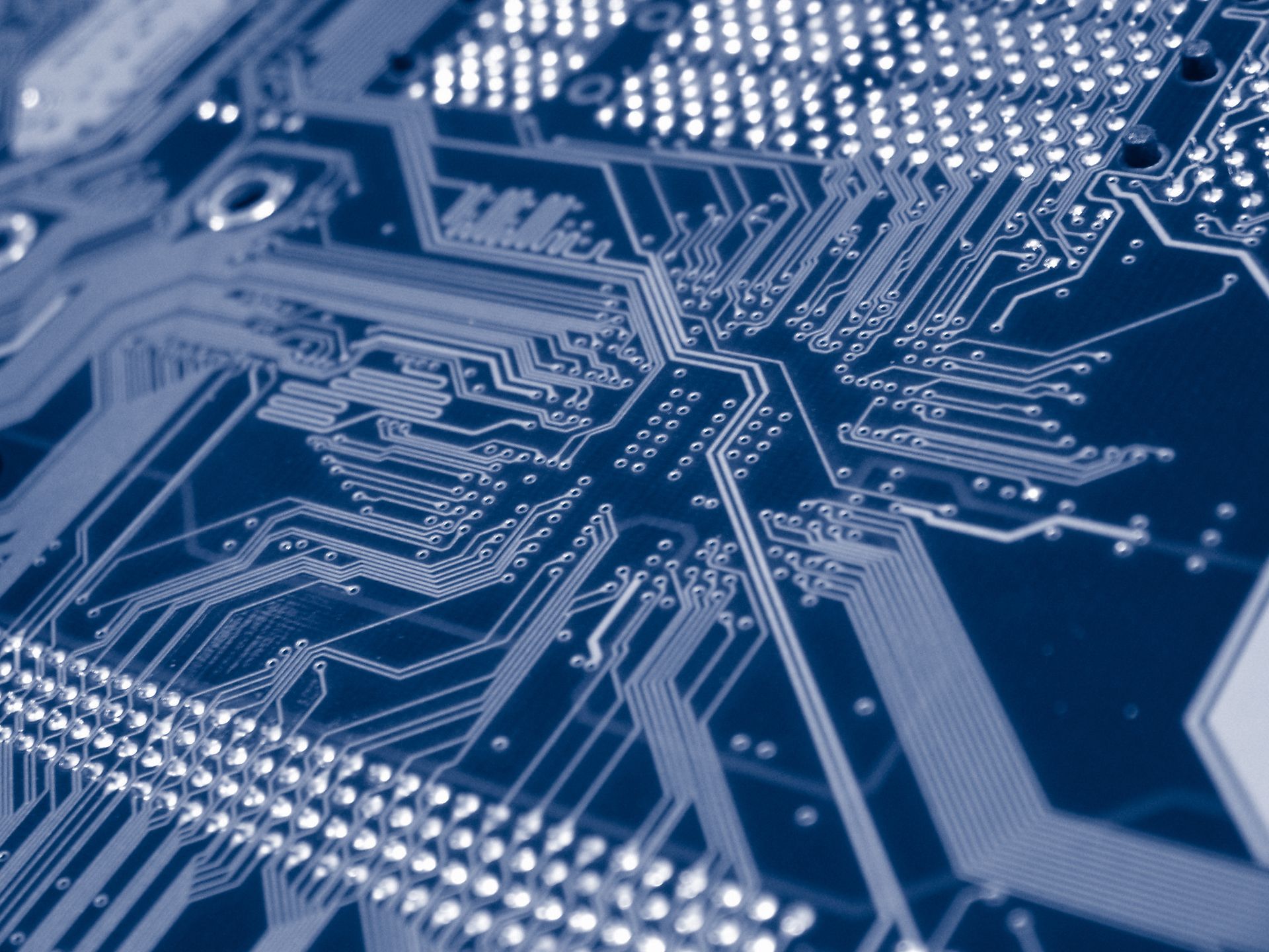 Close-up of a blue printed circuit board with intricate electronic traces and connectors