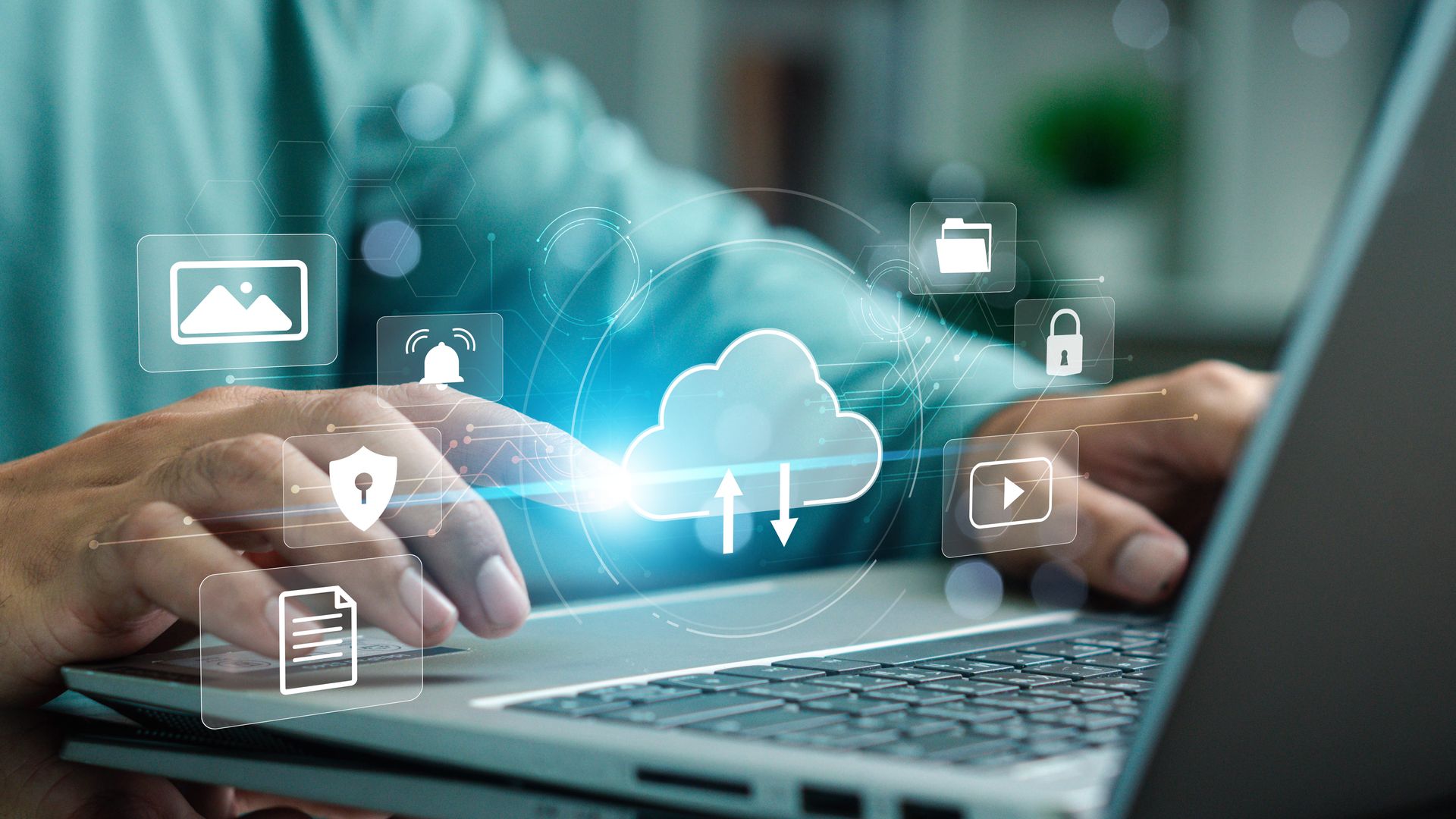 Hands typing on a laptop with glowing cloud storage and app icons overlayed