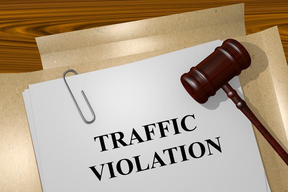Traffic violation notice on a desk with a gavel and paperclip, suggesting a legal penalty.