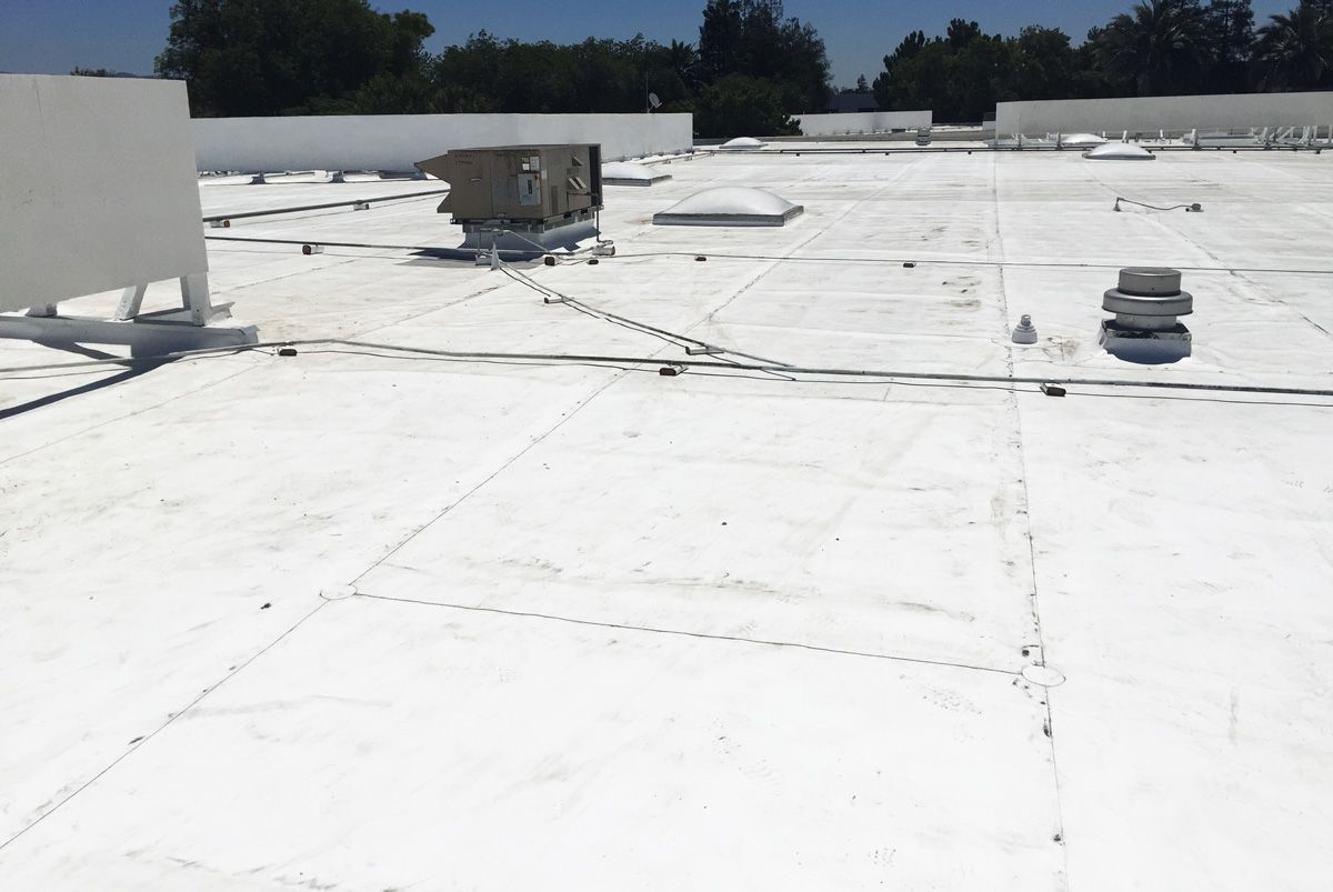 A white roof with a few trees in the background