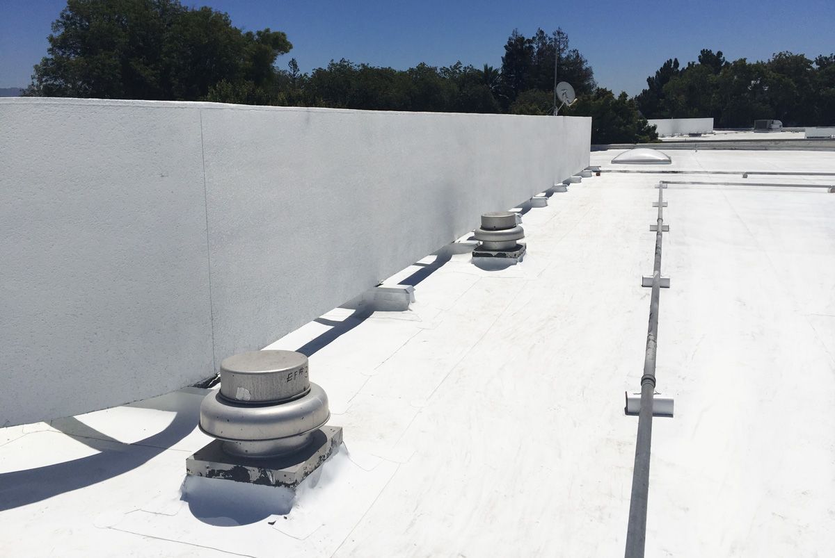 A white roof with a lot of vents on it