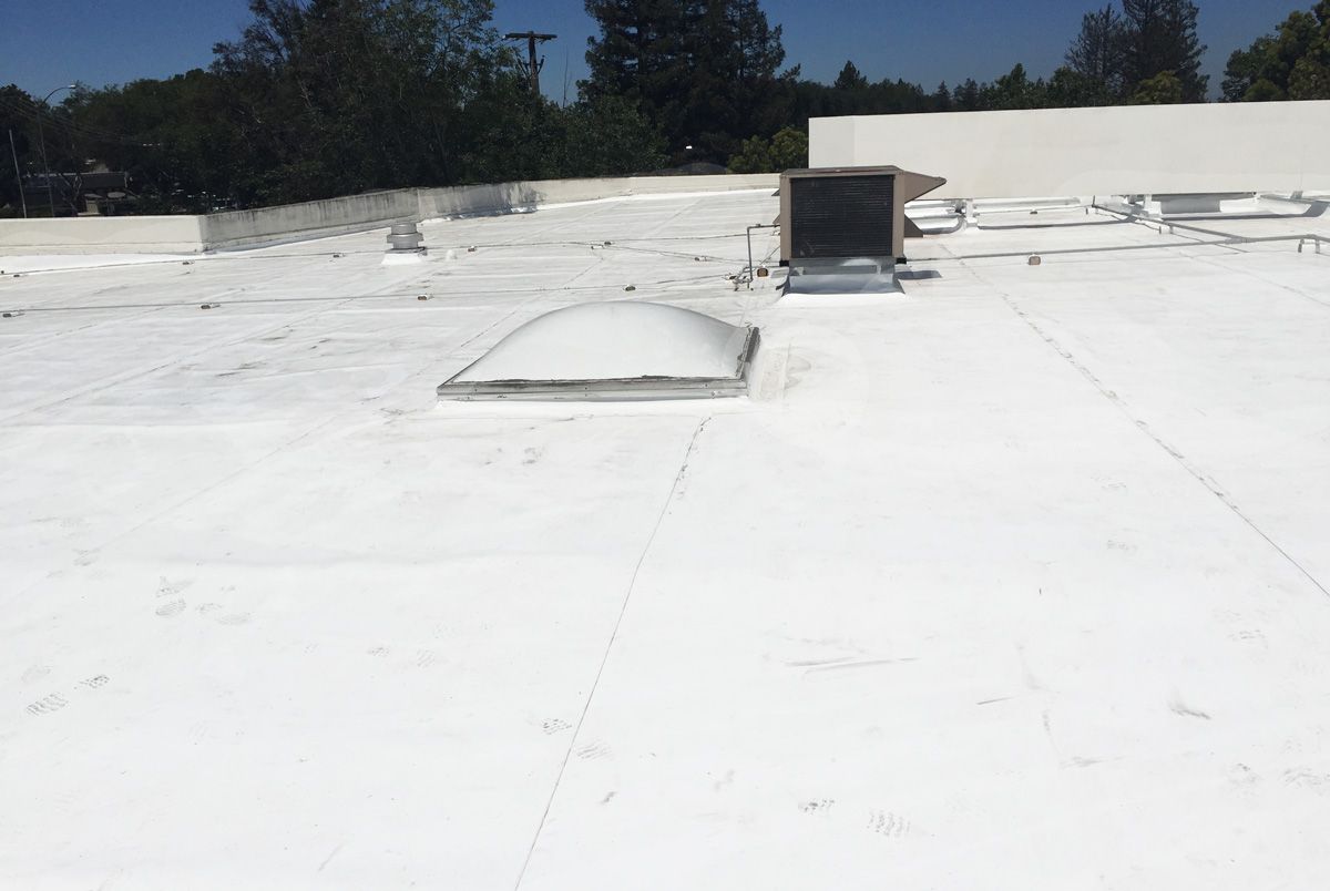 A white roof with a skylight on top of it.