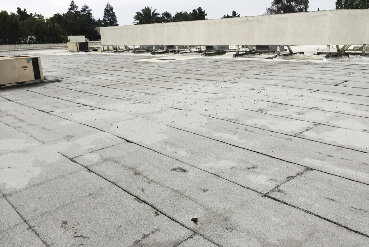 An empty roof with a few trees in the background