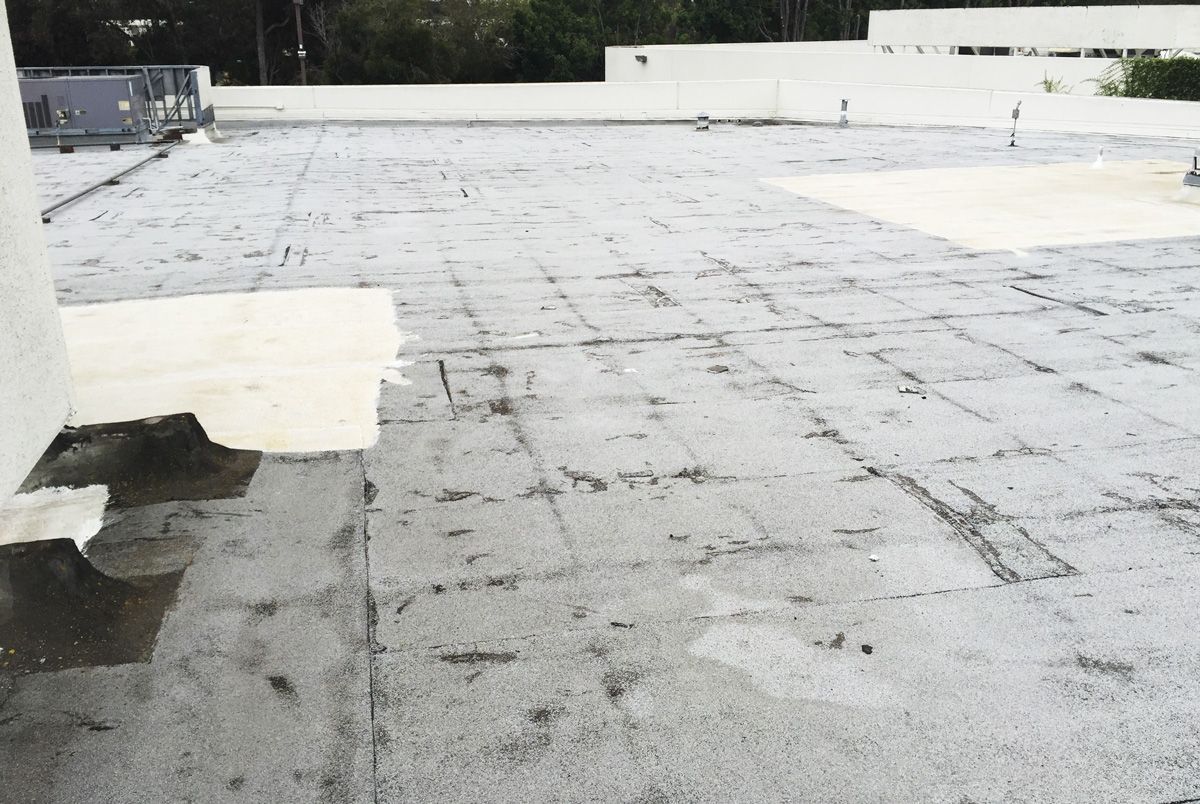 A roof with a lot of holes in it and a white wall in the background.