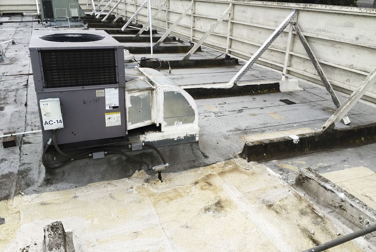 An air conditioner is sitting on the roof of a building.