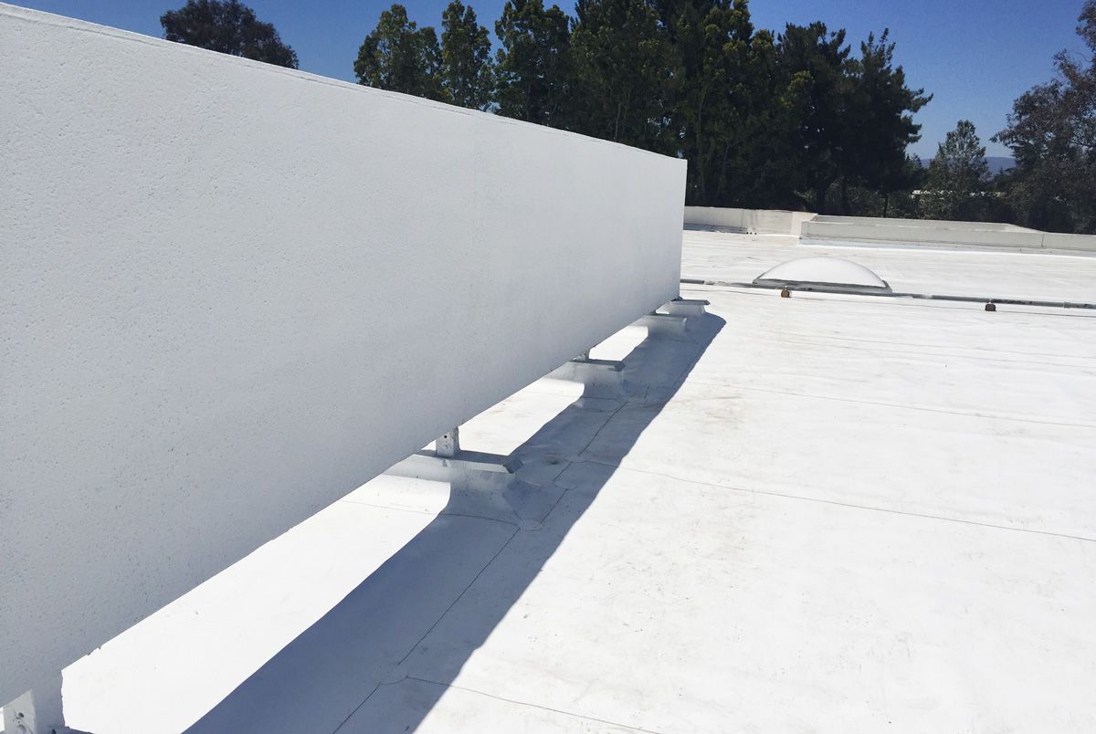 A white fence is sitting on top of a white roof.