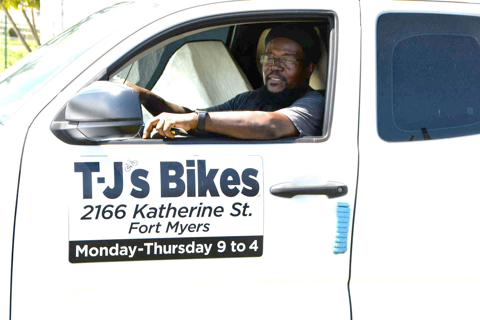 A man is sitting in the driver 's seat of a white truck.