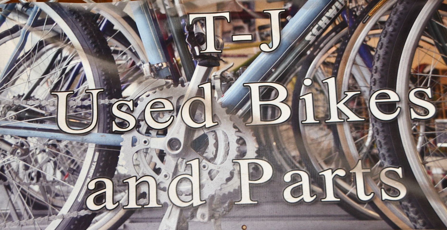 A poster for used bikes and parts with a bicycle in the background