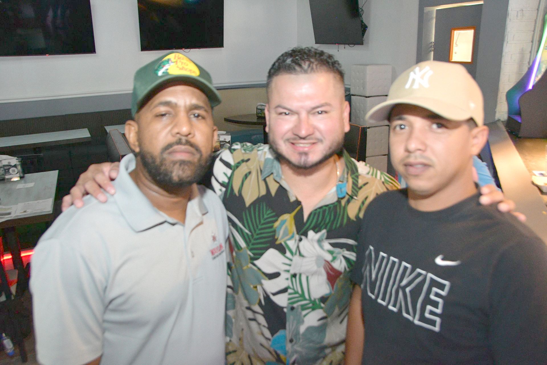 Three men posing for a picture with one wearing a nike shirt