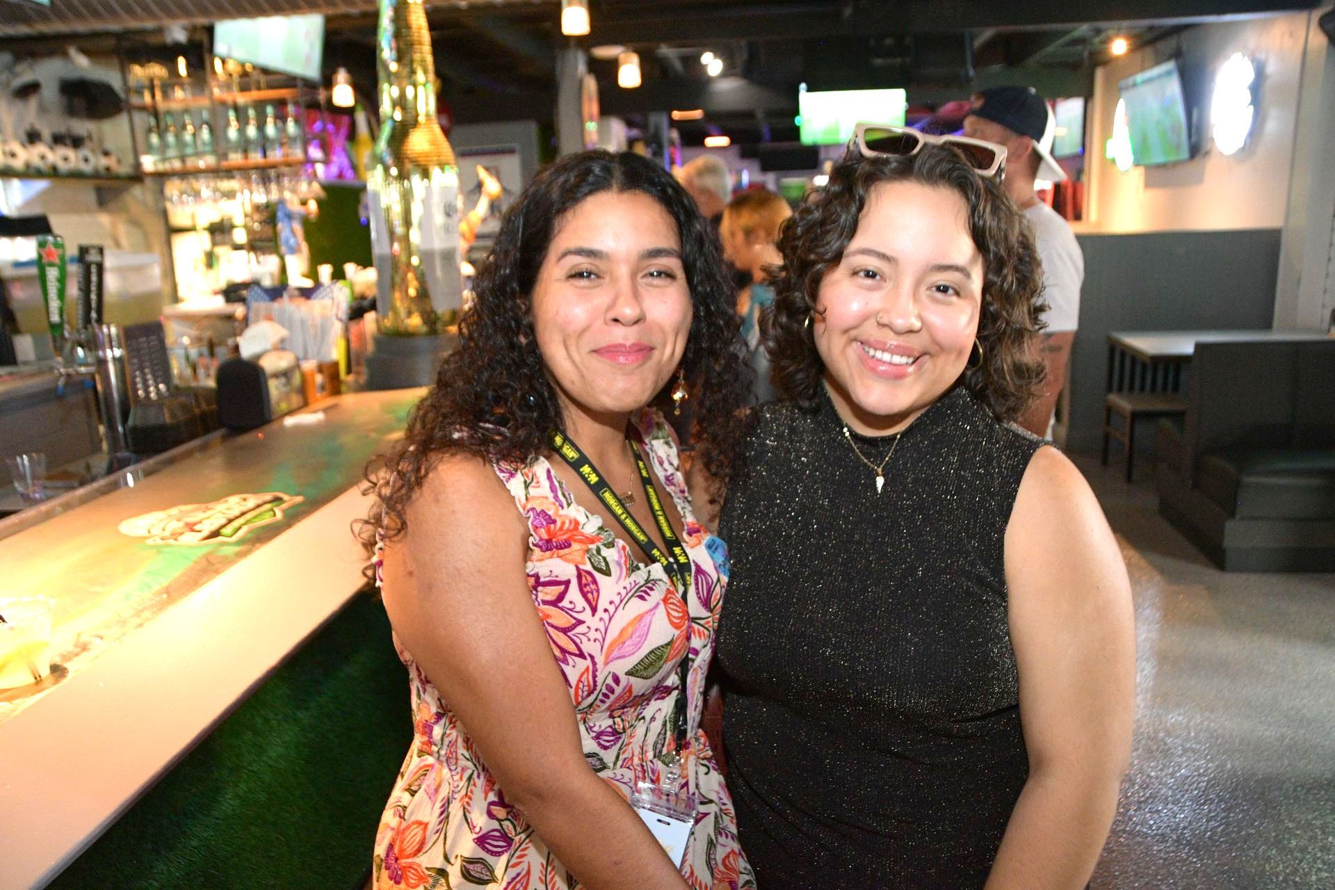Two women are posing for a picture in a restaurant.
