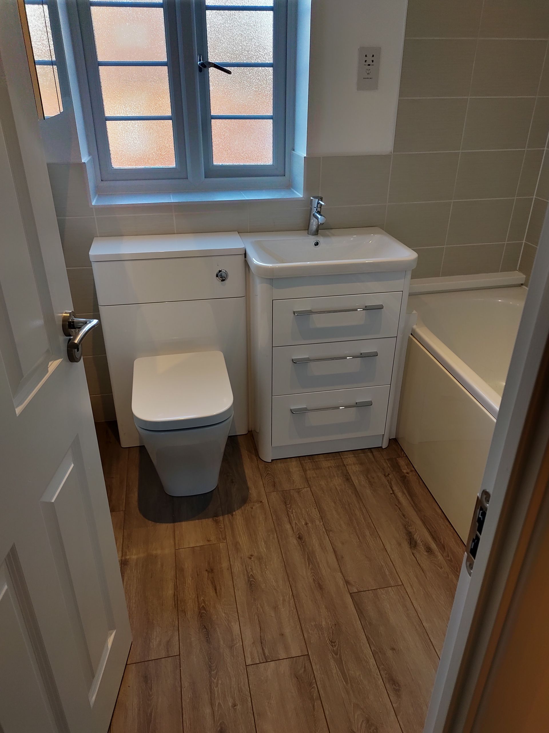 A bathroom with a toilet , sink , and bathtub.