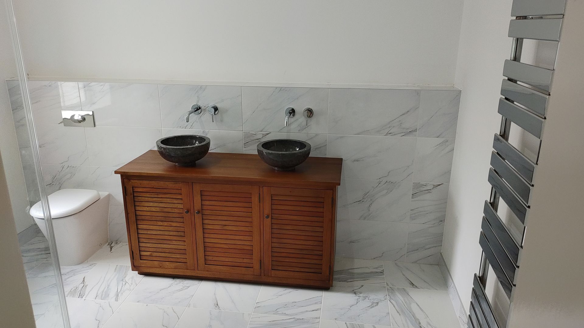 A bathroom with two sinks on a wooden vanity.