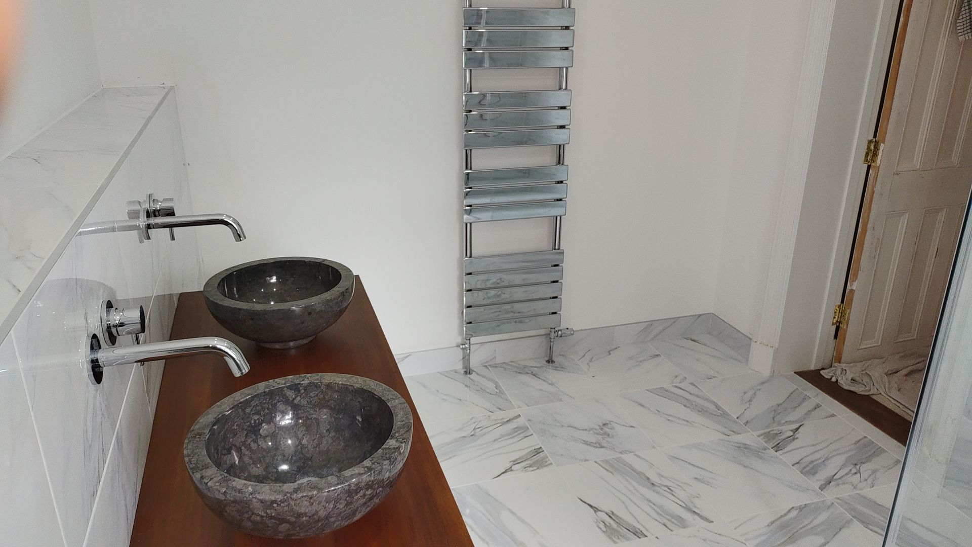 A bathroom with two sinks and a towel rack