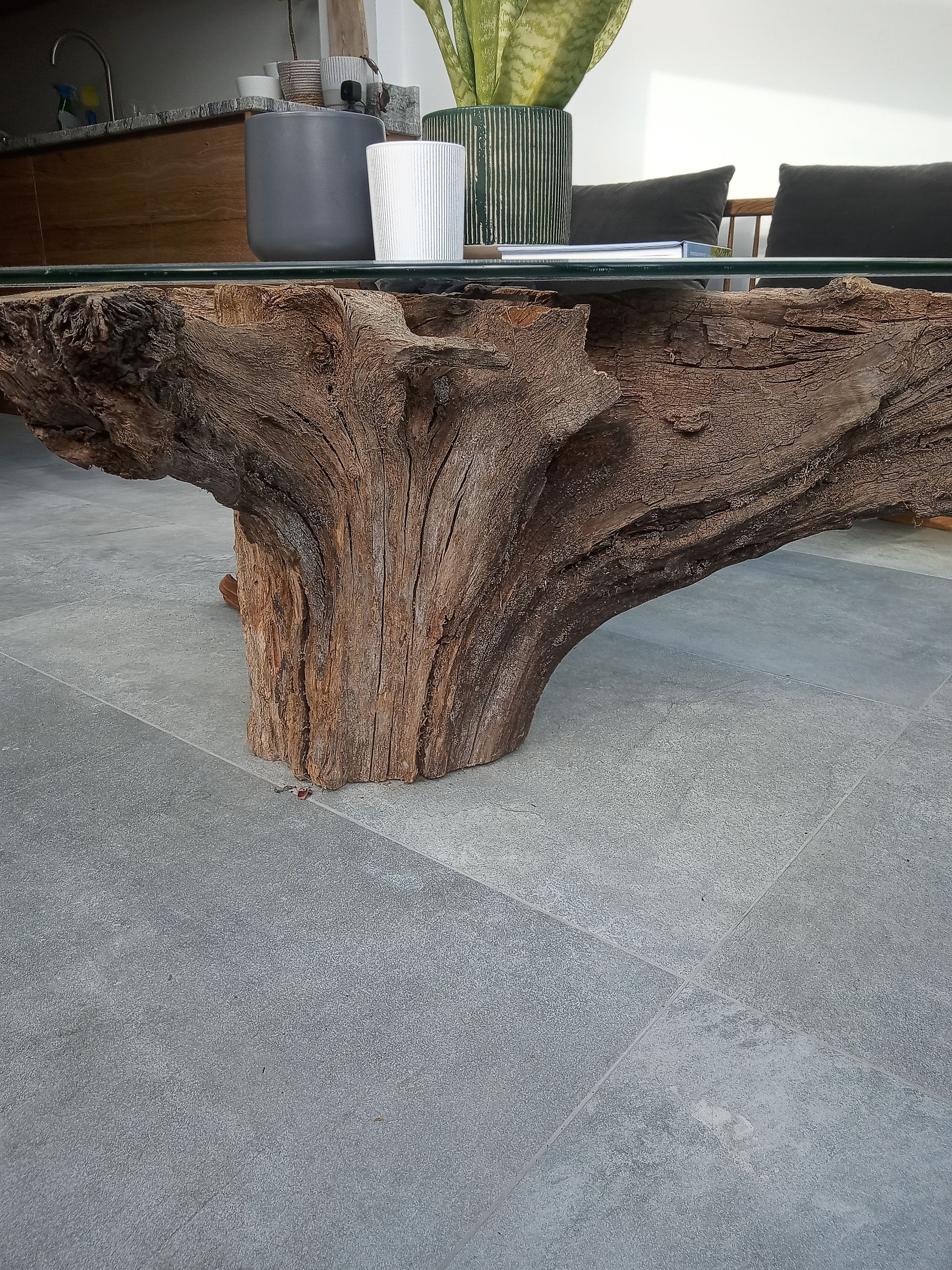 A table made out of a tree trunk with a glass top