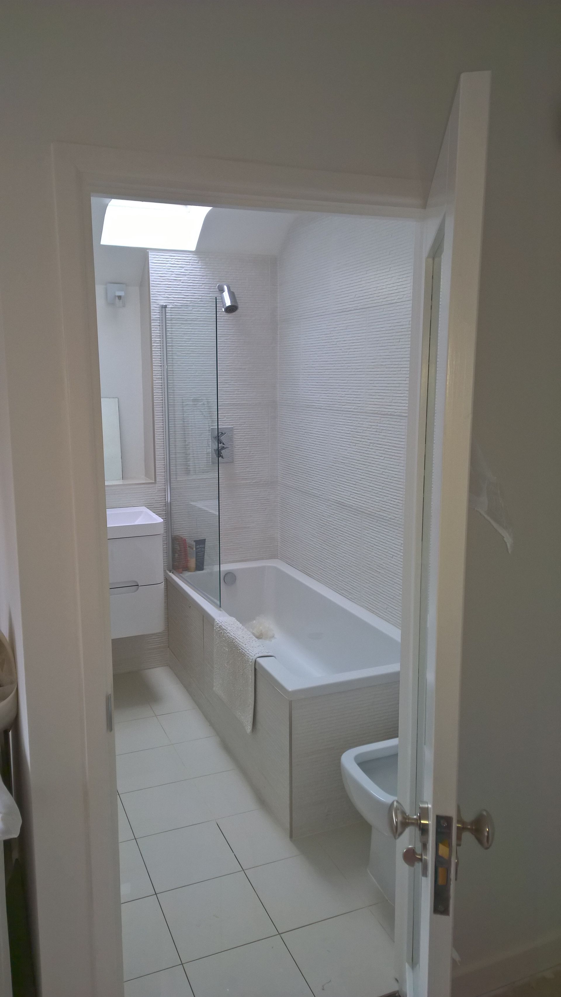 A bathroom with a bathtub , sink , toilet and shower.