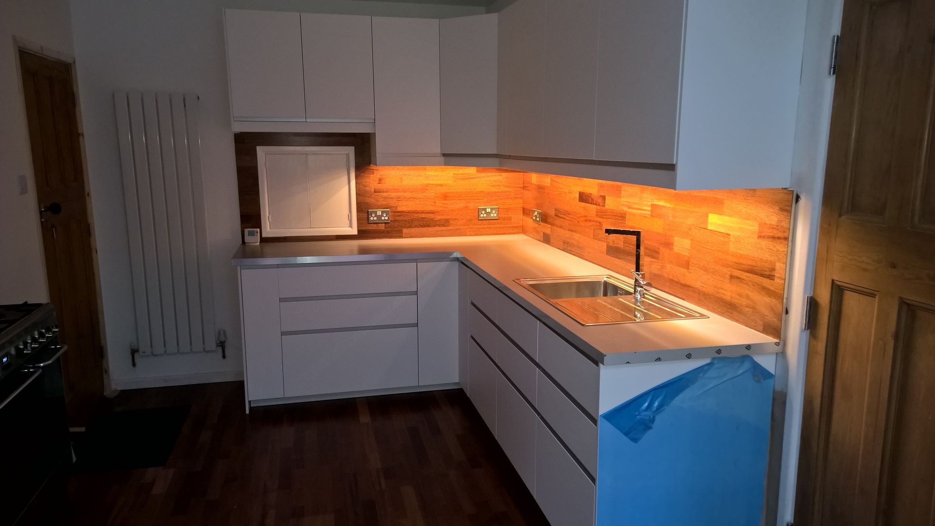 A kitchen with white cabinets , a sink and a stove.