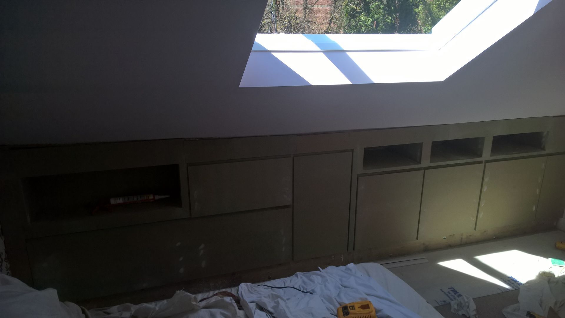 A bedroom with a skylight in the ceiling