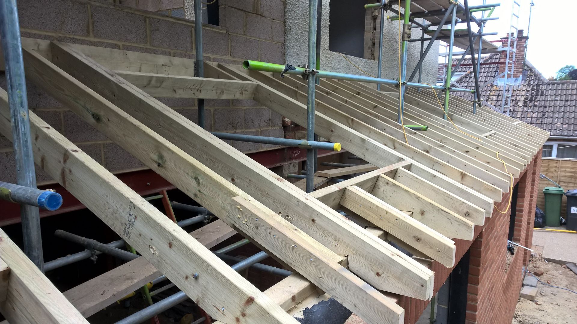 A roof is being built with wooden beams and scaffolding.