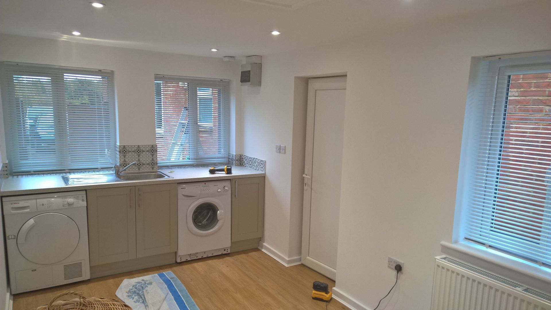 A kitchen with a washing machine , dryer , and sink.